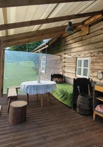 a wooden cabin with a table on a deck at Pirkia Miške in Kazitiškis