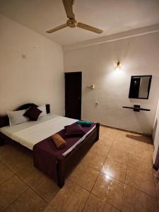 a bedroom with a bed and a flat screen tv at Sunset Paradise Talalla in Talalla South
