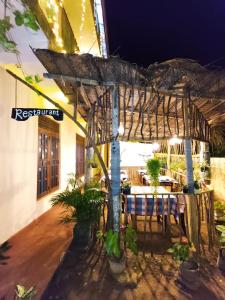 a restaurant with a table and chairs under a pergola at Sunset Paradise Talalla in Talalla South
