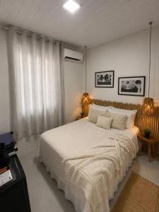 a bedroom with a large bed with white sheets at Estrela Praia in Fernando de Noronha