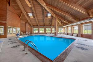 a large swimming pool in a building with wooden ceilings at Best Western Geneseo Inn in Geneseo
