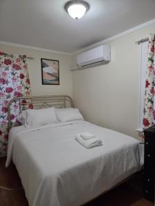 a bedroom with a white bed with a white blanket at Stay by Gina in Irvington