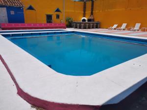 an empty swimming pool with chairs in a building at Hotel Tlacotalpan in Tlacotalpan +25 photos