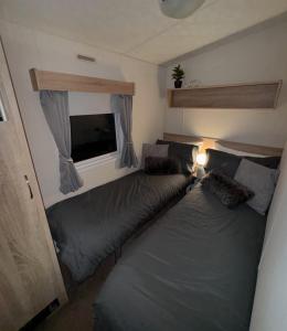a bedroom with two beds and a flat screen tv at Haighs caravan hire in Rhyl