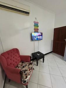 a living room with a red couch and a tv at Central Calm Apartment in Dar es Salaam