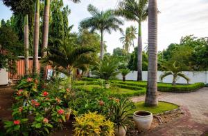 a garden with palm trees and flowers at Central Calm Apartment in Dar es Salaam +3 photos