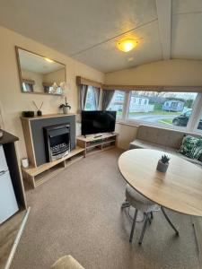 a living room with a table and a fireplace at Haighs caravan hire in Rhyl