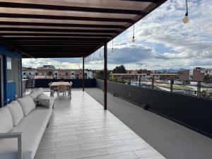 a balcony with a couch and a table on a roof at Outlanders House BOG Airport in Bogotá