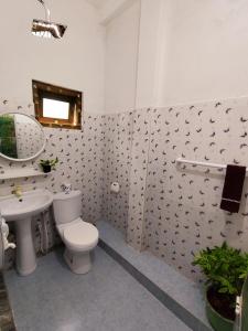 a bathroom with a white toilet and a sink at Sunset Paradise Talalla in Talalla South