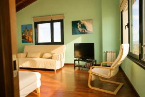 a living room with a couch and a tv at La Cepada in Carrandi