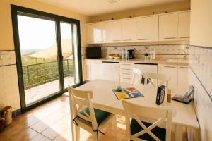 a kitchen with a table and chairs with a view at La Cepada in Carrandi