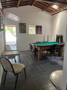 ein Zimmer mit einer Tischtennisplatte und Stühlen in der Unterkunft Chácara in Conde