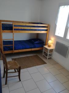 a bedroom with bunk beds and a chair and a tv at La Salamandre in Fouras