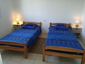 two beds in a small room with two lamps at La Salamandre in Fouras