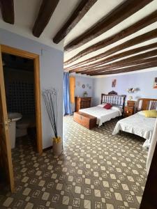 a bedroom with two beds and a bathroom at Los Chinchanes in Santa Cruz de Grío