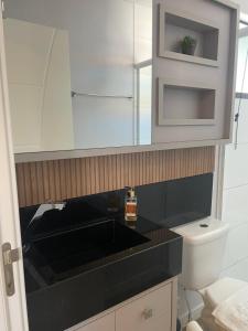 a bathroom with a black counter top and a toilet at Studio Pomerode in Pomerode +42 photos