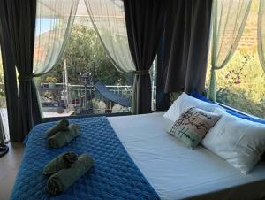 two stuffed animals sitting on a bed in front of a window at Drop of Heaven in Katokhórion +67 photos
