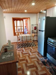 a kitchen with a refrigerator and a table in it at Refugio Rancagua in Pueblo de Naturales