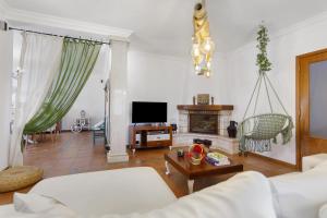 a living room with a couch and a tv at Sol Lua House in Fátima
