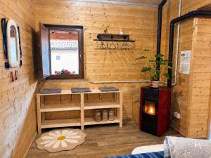 a room with a wooden wall with a window and a stove at Le scalette di Giocondo in Roio Piano