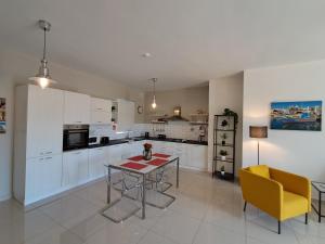 a kitchen with a table and a yellow chair at Lanyard Hitch Court in Marsaxlokk