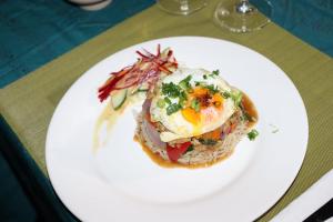 a plate of food with an egg on top of pasta at Mountain Panoramic Suite in Trou d'Eau Douce