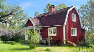 a red house with a red roof at Hus Hultsnäs in Högsby
