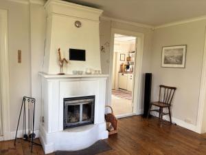 a living room with a fireplace and a chair at Hus Hultsnäs in Högsby