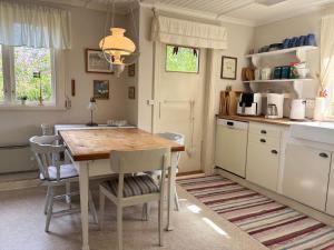a kitchen with a table and chairs in a room at Hus Hultsnäs in Högsby