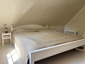 a white bed in a room with a attic at Hus Kråksmåla in Alsterbro