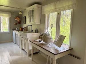 a kitchen with a table with a sewing machine on it at Hus Kråksmåla in Alsterbro