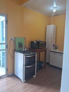 a kitchen with a stove and a refrigerator at Ground floor apartment steps from the Cathedral in Santo Ângelo