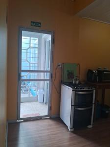 a kitchen with a stove and a door to a patio at Ground floor apartment steps from the Cathedral in Santo Ângelo +4 photos