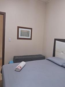 a bedroom with a bed with a towel on it at Ground floor apartment steps from the Cathedral in Santo Ângelo