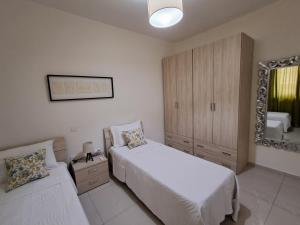 a bedroom with two beds and a mirror at Lanyard Hitch Court in Marsaxlokk