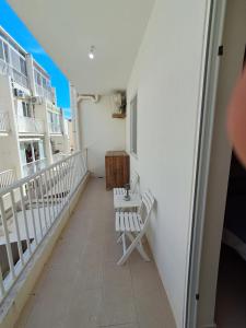 a balcony with two white chairs on a building at Lanyard Hitch Court in Marsaxlokk +2 photos