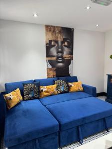 a blue couch in a living room with a painting at Secret Garden Suite in Gloucestershire