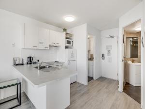 a kitchen with white cabinets and a counter top at Nautilus Private Rooftop Spa in Mooloolaba
