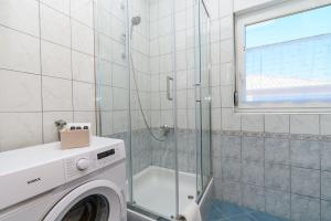 a washing machine in a bathroom with a shower at Apartments Andrija in Palit +62 photos