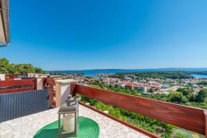 a table on a balcony with a view of the city at Apartments Andrija in Palit