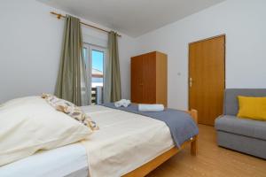 a bedroom with a large bed and a chair at Apartments Andrija in Palit