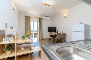 a kitchen and living room with a stainless steel sink at Apartments Andrija in Palit