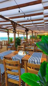 two wooden tables and chairs under a wooden pergola at Panorama Chantall-izby,apartmány s výhľadom na more in Ravda