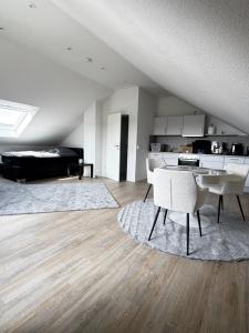 ein Wohnzimmer mit Tisch, Stühlen und einem Bett in der Unterkunft Studio No 1 in Heinsberg