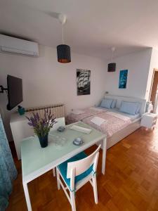 a bedroom with a bed and a table and a table and chairs at Vista Esmeralda in Opatija