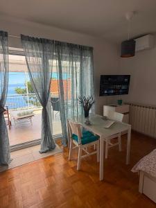 a dining room with a table and a view of the ocean at Vista Esmeralda in Opatija