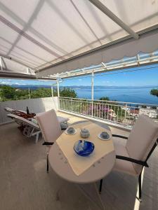 a table and chairs on a balcony with a view of the ocean at Vista Esmeralda in Opatija