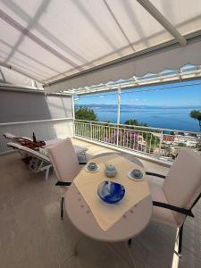 a table and chairs on a balcony with a view of the ocean at Vista Esmeralda in Opatija