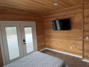 a bedroom with a bed and a flat screen tv at Cedar Studios at Whitetail Estates in Babbitt