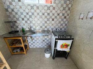 a small kitchen with a sink and a stove at Brisa da Mata Suítes BF quarto 02 in Baía Formosa